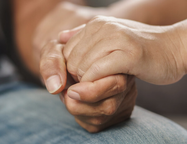 Two people holding hands, symbolizing compassion and inclusivity.